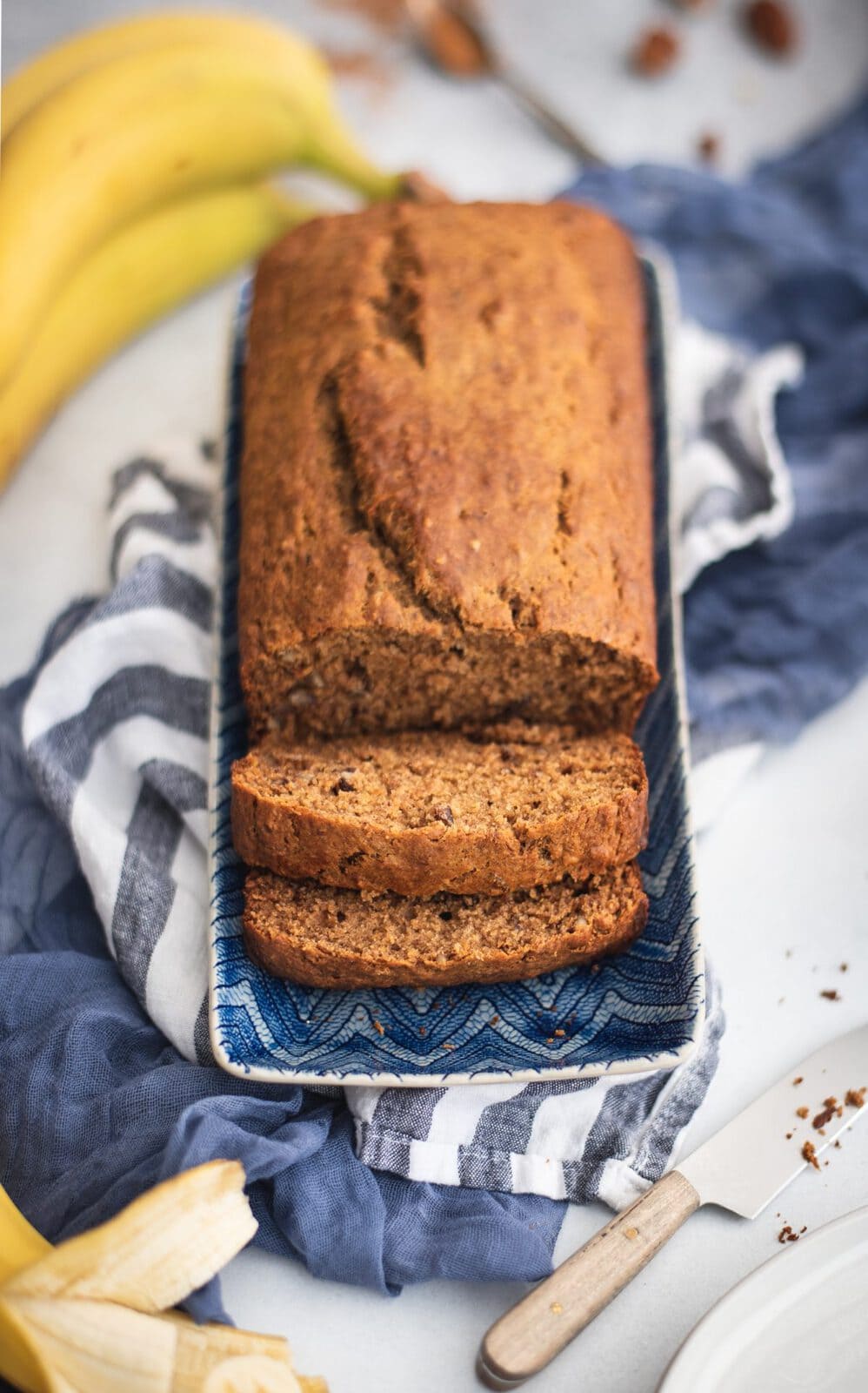 Blue plate with healthy banana bread loaf and slices