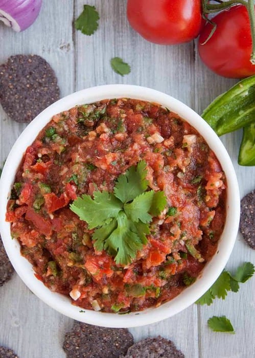10 minute fresh blender salsa with tomatoes, onion, jalapeño, cilantro and just the right amount of kick to have you coming back for more.