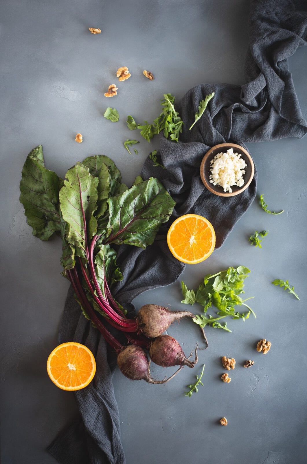 Overhead picture of arugula salad with roasted beets and orange slices ingredients