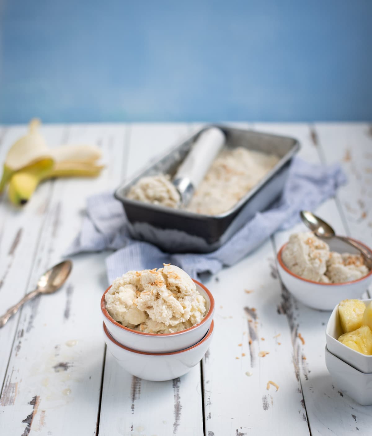 two bowls of banana ice cream with bananas and tin of ice cream