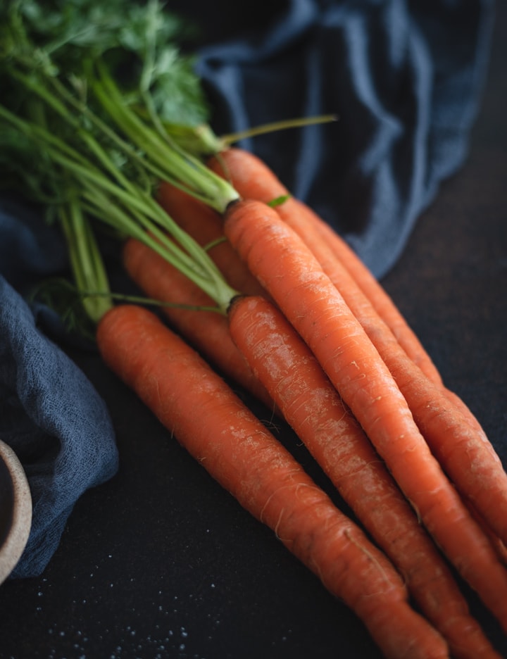 pile of carrots on dark background