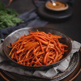 bowl of carrot fries on dark background