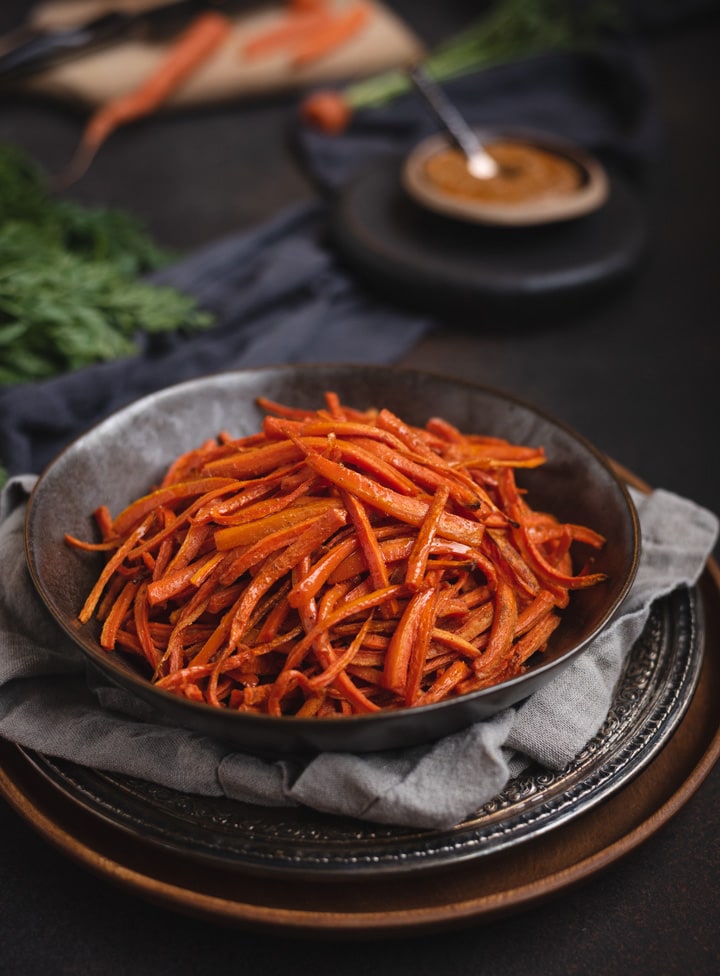 bowl of carrot fries on dark background
