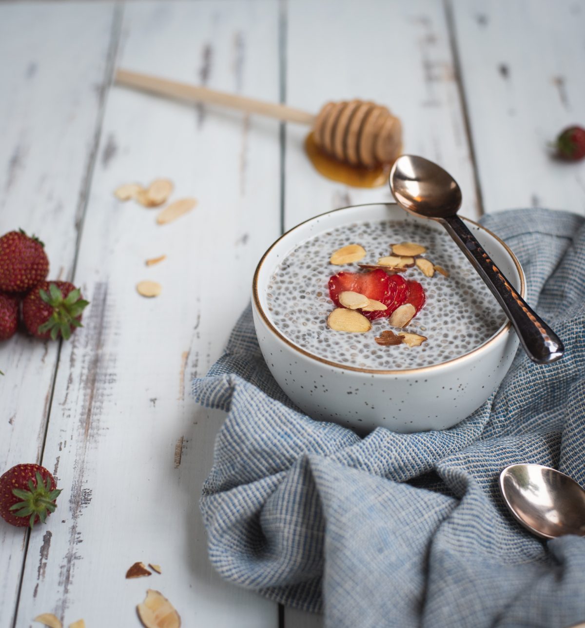 Up close photo of a bowl of almond chia seed pudding topped with strawberries