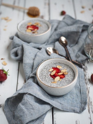 Picture of almond chia seed pudding on a table with strawberries