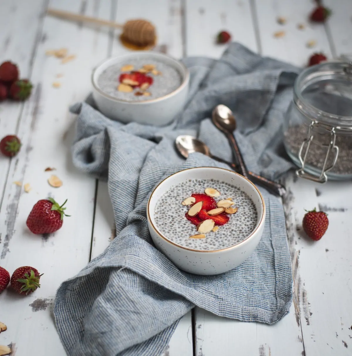 Picture of almond chia seed pudding on a table with strawberries