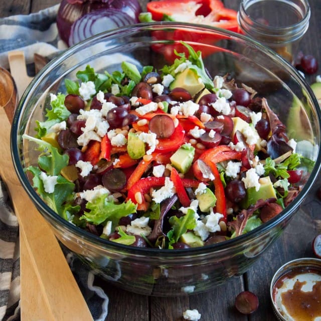 Close up picture of green salad with grapes and feta and curry balsamic dressing 