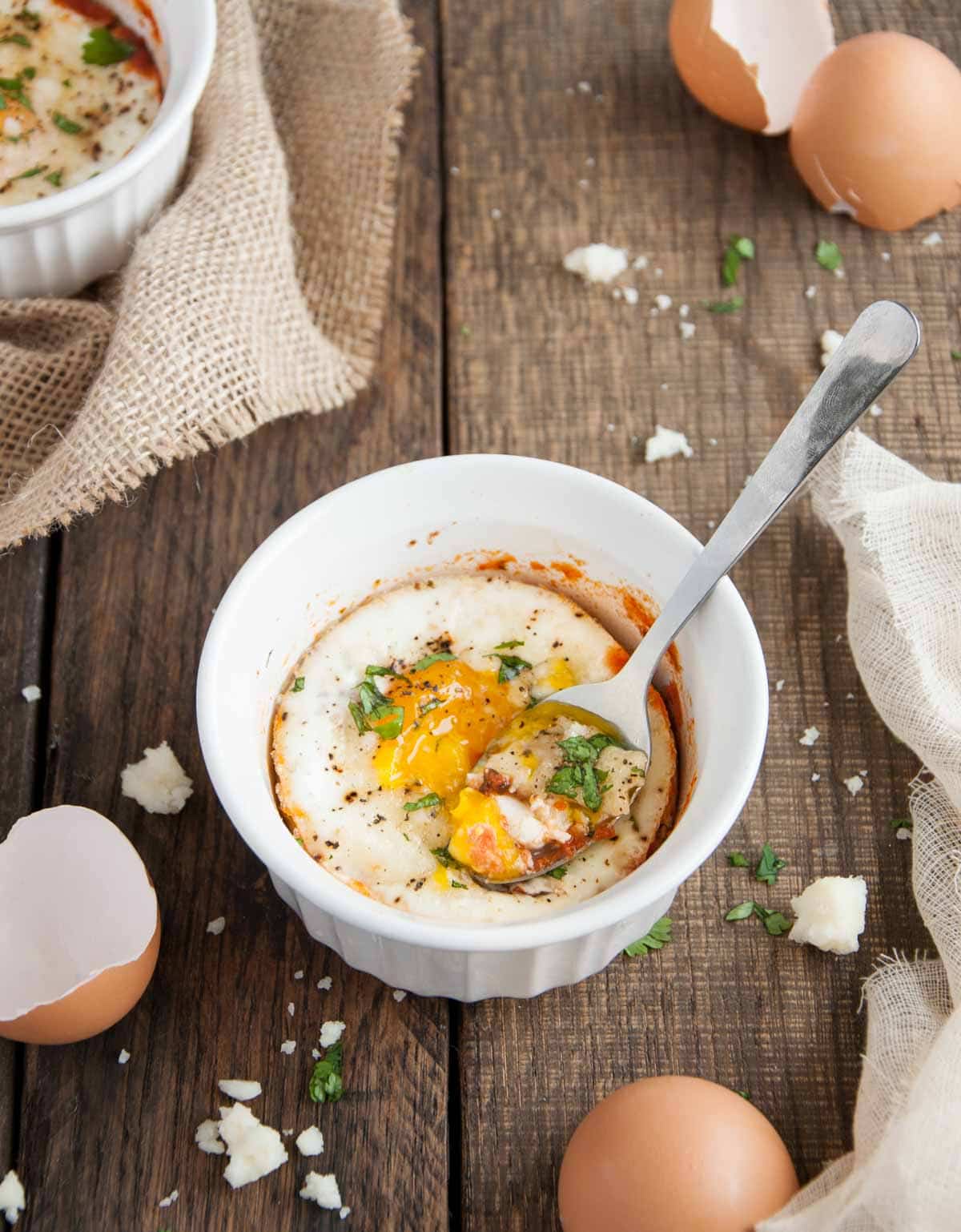 Spoon in a bowl of baked eggs.