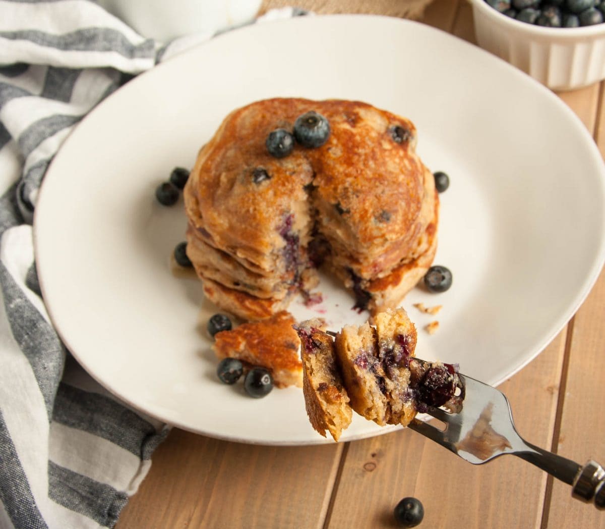 These thick, rich, delicious yogurt pancakes are a breakfast winner both in taste and nutrition, made with whole wheat flour, Greek yogurt, and blueberries.