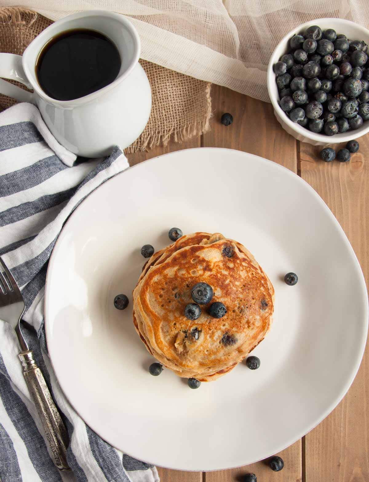 These thick, rich, delicious yogurt pancakes are a breakfast winner both in taste and nutrition, made with whole wheat flour, Greek yogurt, and blueberries.