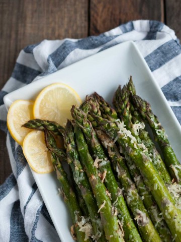 It will take longer for the oven to heat up than to prep this tasty lemon parmesan asparagus! Simple ingredients come together in this classic versatile side dish. - Feasting Not Fasting