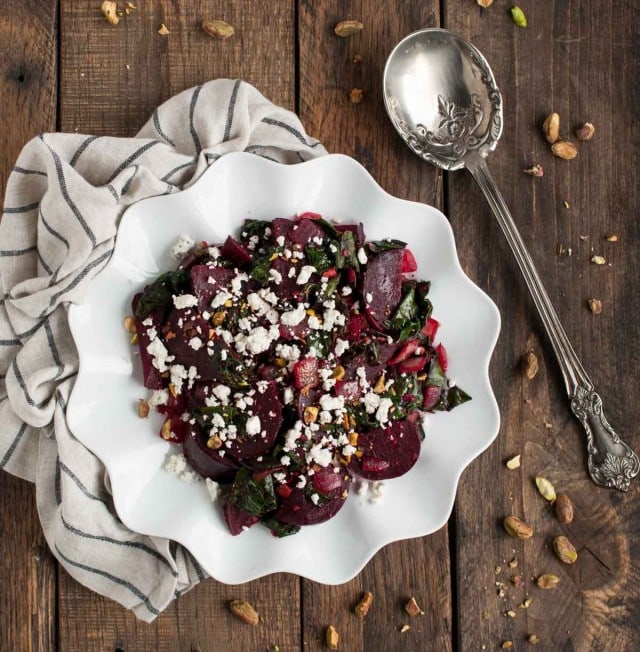 These light, delicious sautéed beet greens are tossed in tangy vinegar and spices before being topped with roasted beets, crushed pistachios, and crumbles of goat cheese.