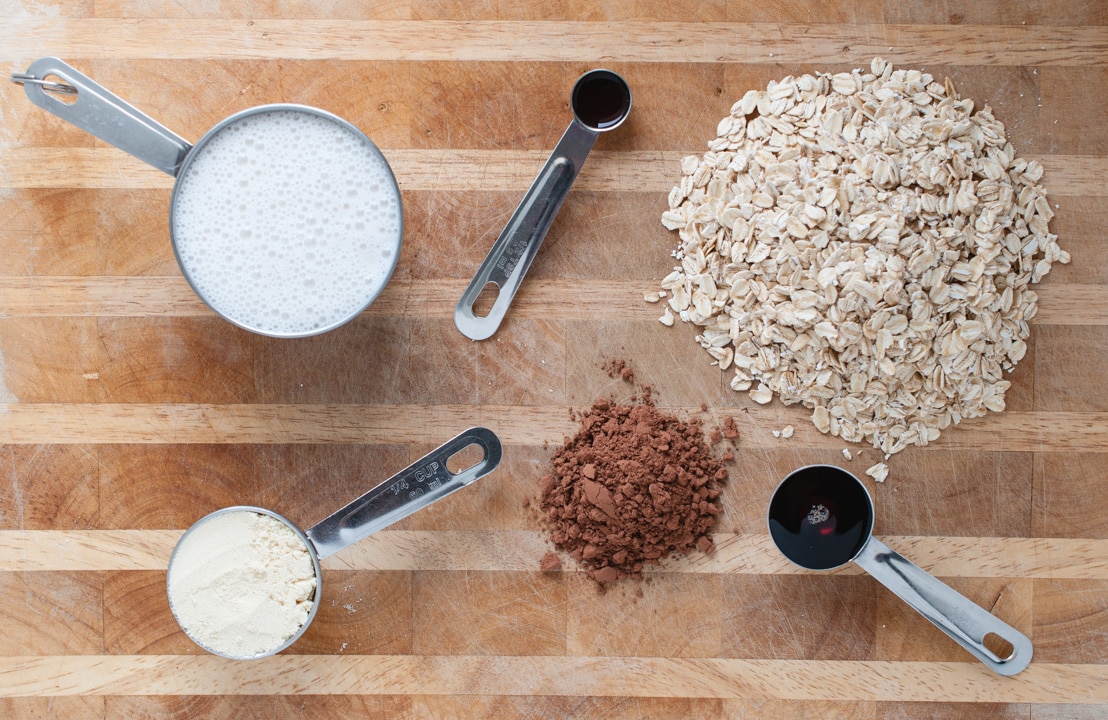 cutting board with oats, milk, and other overnight oat ingredients