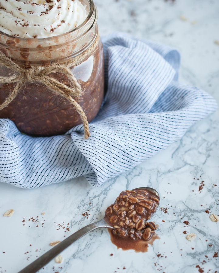 spoonful of chocolate oatmeal with jarful in background