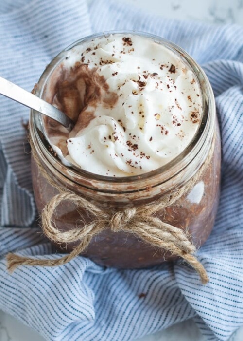 close up overhead picture of chocolate overnight oats with whipped cream on top