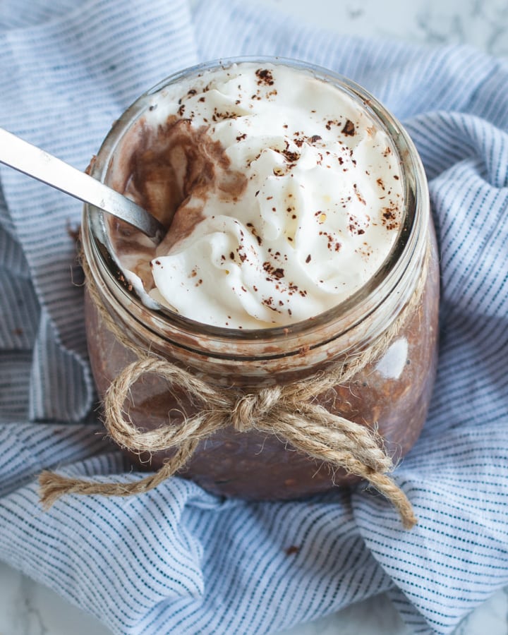 close up overhead picture of chocolate overnight oats with whipped cream on top