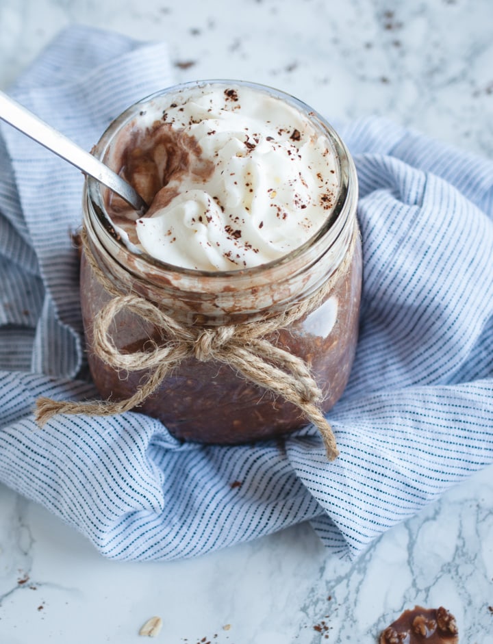 jar of chocolate protein overnight oats with spoon in it