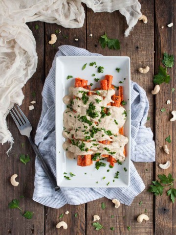 Cashew cream sauce is drizzled over perfectly roasted caramelized carrots in this easy, flavorful, absolutely delicious, naturally vegan dish.