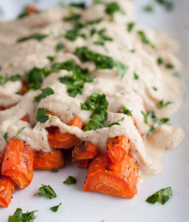 Cashew cream sauce is drizzled over perfectly roasted caramelized carrots in this easy, flavorful, absolutely delicious, naturally vegan dish.