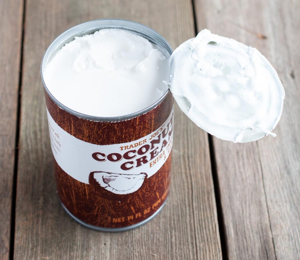 opened can of coconut cream on a wood backdrop