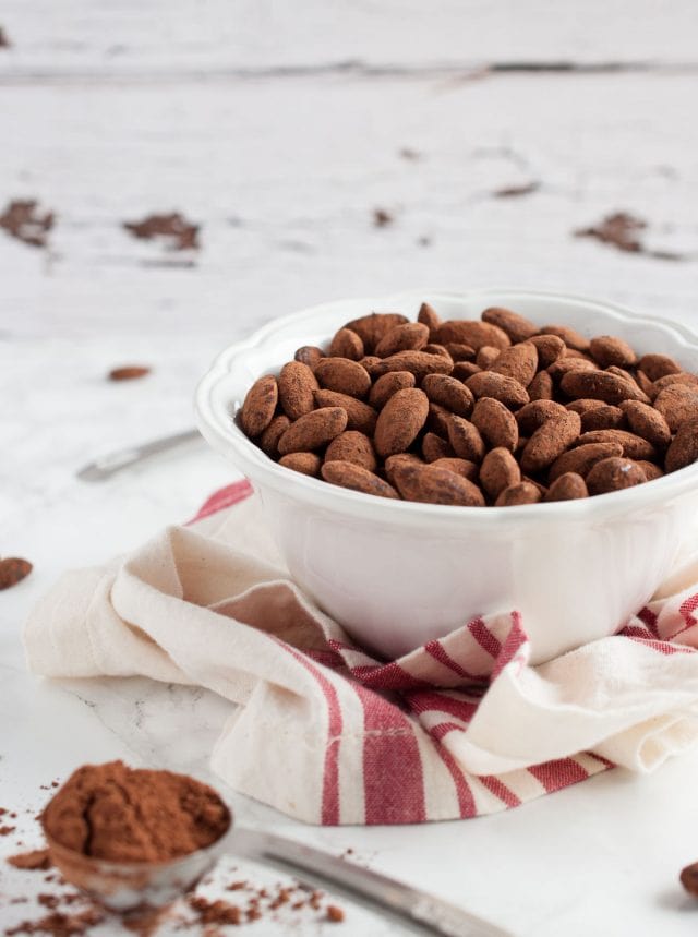 cocoa roasted almonds from the side view on a white background 