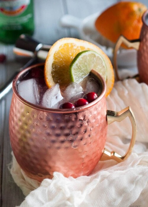 Cranberry Moscow mules made with zesty orange, zippy ginger beer, vodka, lime, and cranberry just might be the most refreshing drink on the planet. Try one today with this recipe!