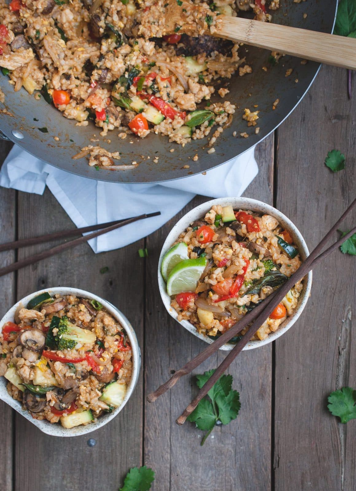 Close up overhead shot of two bowls of Thai fried brown rice