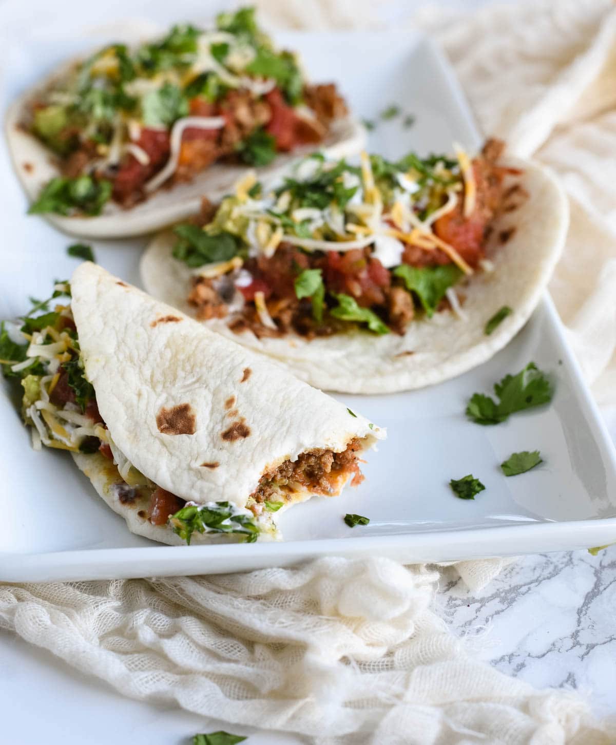 up close photo of ground turkey tacos with one half eaten