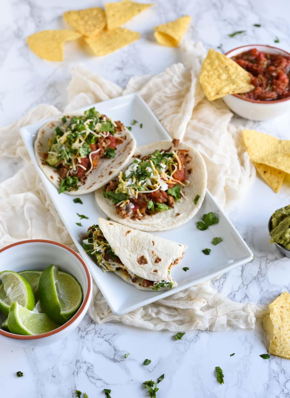 Overhead picture of taco plate with a bite taken out of one taco