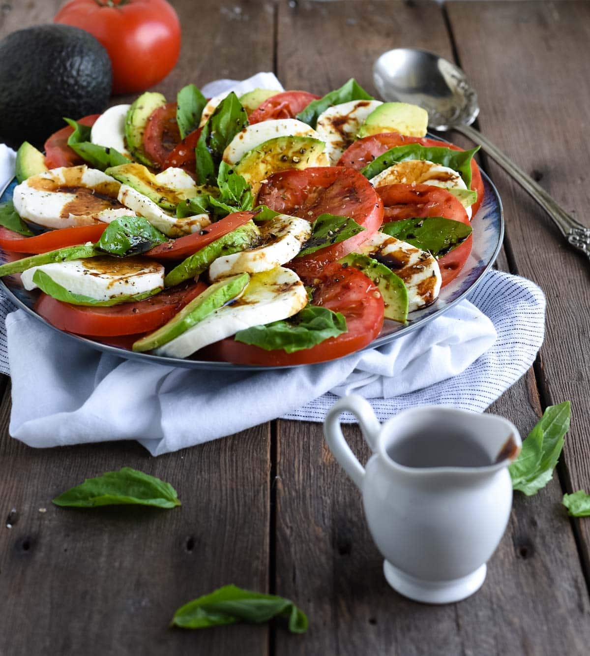 avocado caprese salad shot on wood backdrop