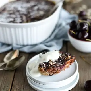 Slice of healthy cherry oat bake with yogurt topping