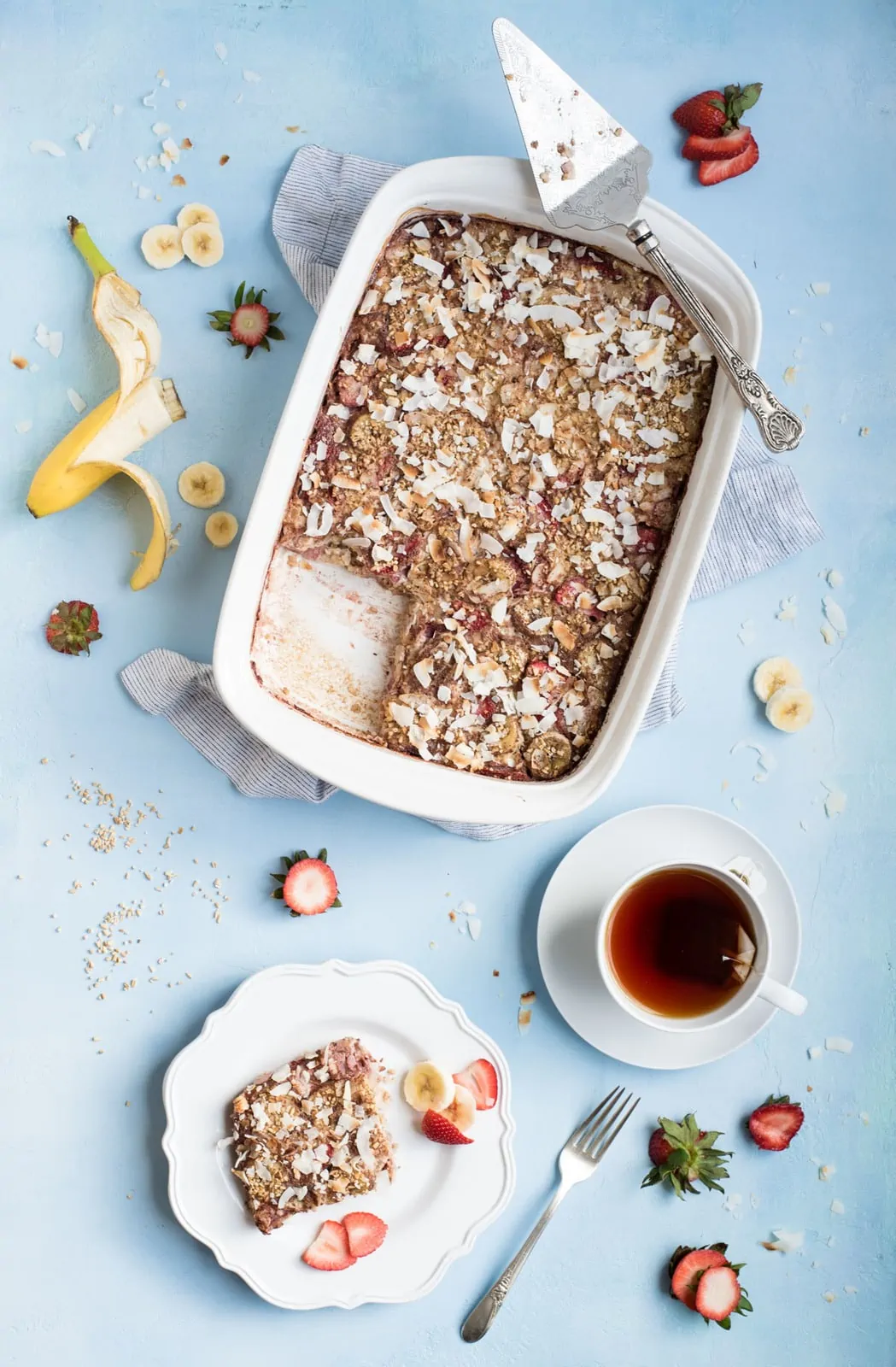 Strawberry Banana Steel Cut Oat Bake overhead picture of dish with one serving and cup of tea