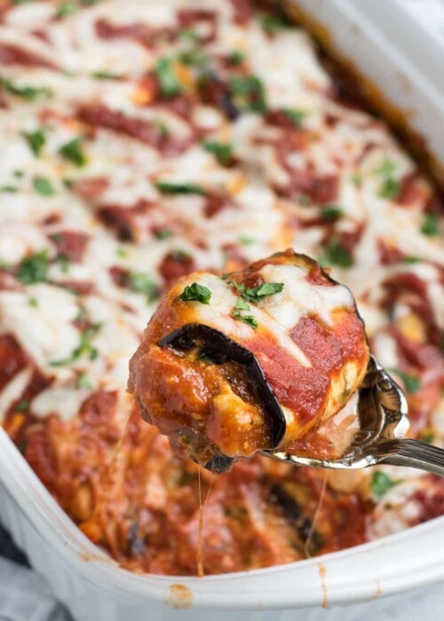 eggplant lasagna roll ups with one roll being served from a spoon