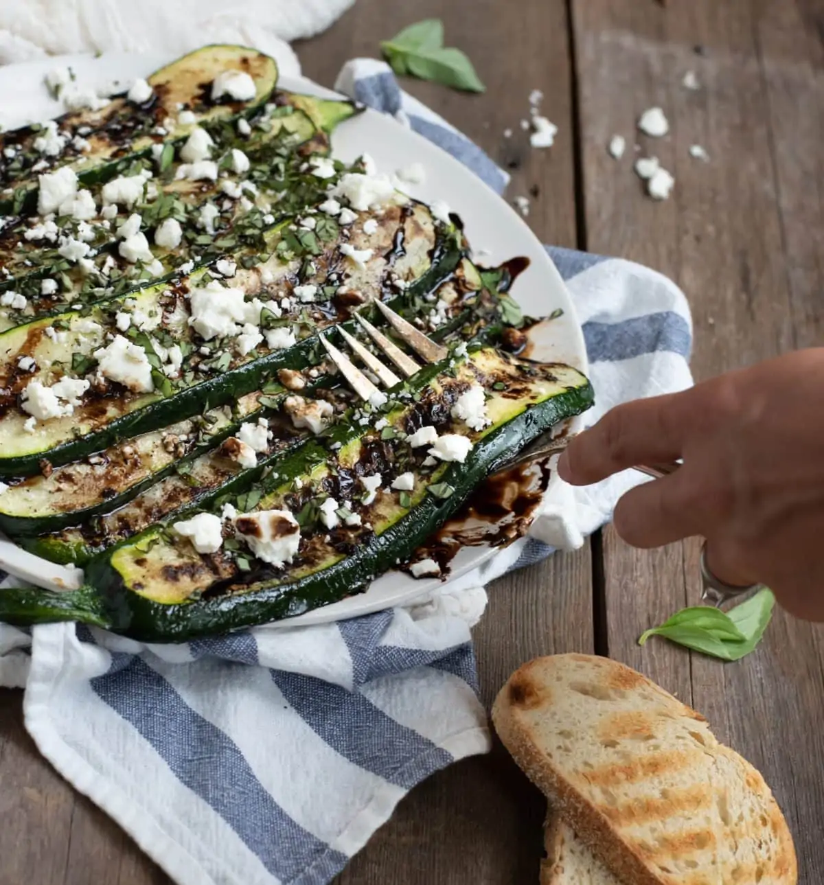 grilled zucchini being lifted with a fork