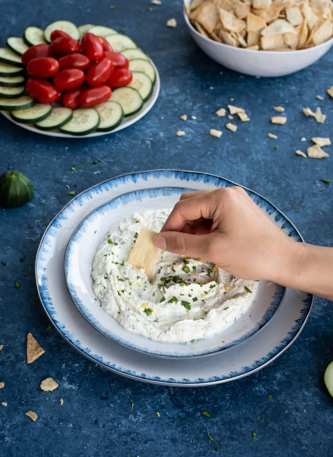 Hand with chip scooping whipped feta with herbs