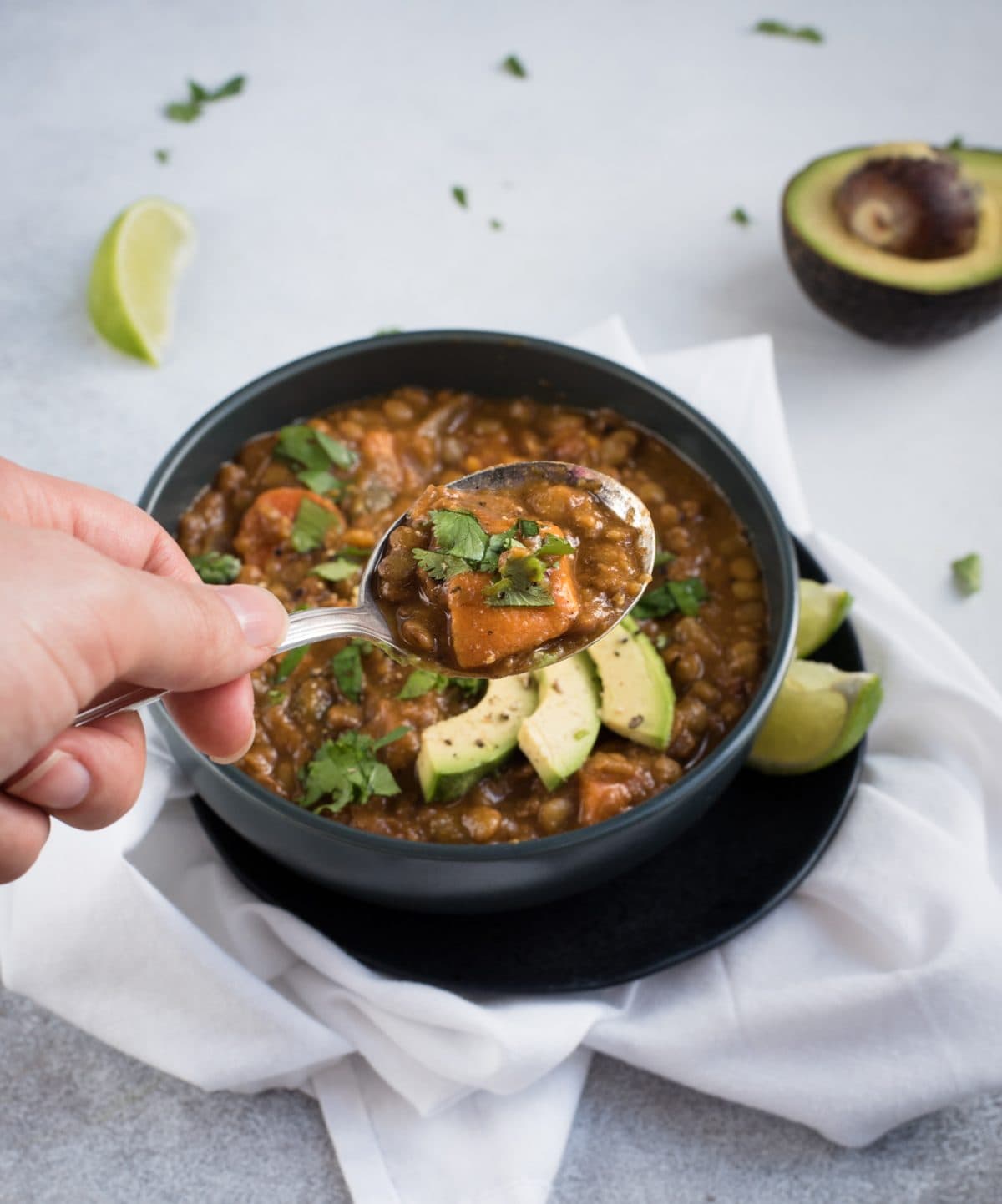 Photo of spoon of sweet potato lentil soup over a bowl