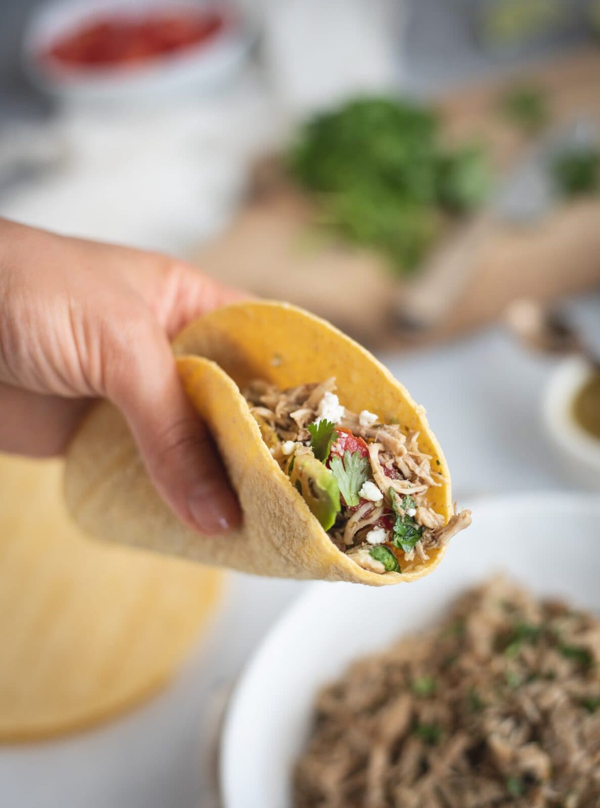 Hand holding Slow Cooker Cilantro Lime Chicken taco