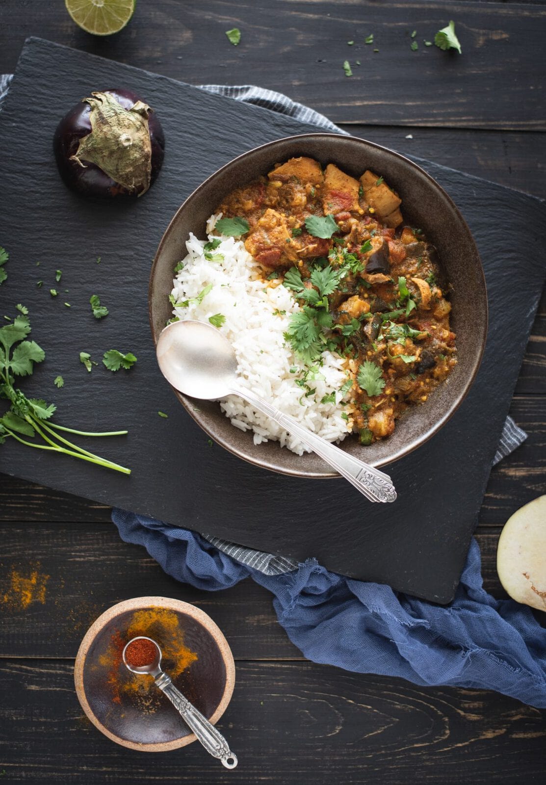 Bowl of chicken curry with eggplant with rice on a dark background