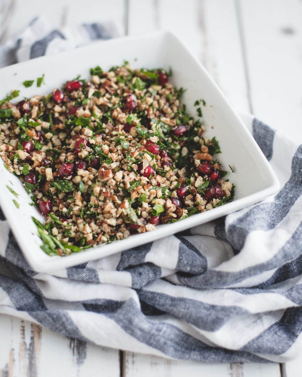 Tossed pomegranate, parsley, and crushed pecans in a bowl