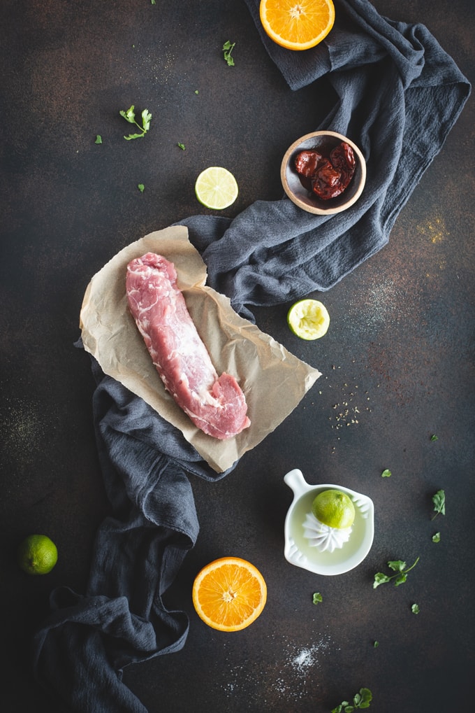 overhead picture of pork tenderloin tacos ingredients on a dark background