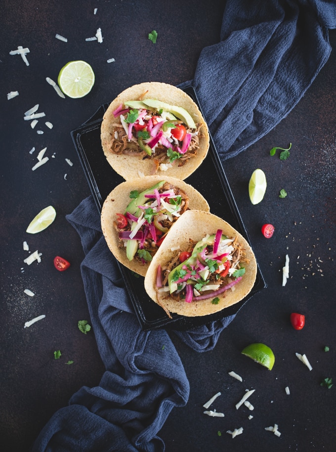 Overhead picture of carnitas tacos on a black background