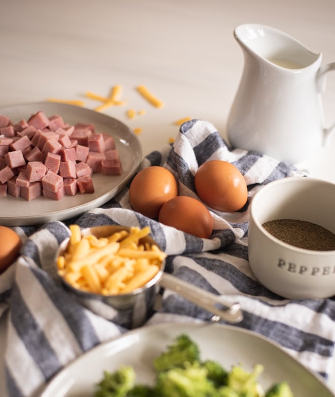 eggs, ham, cheese, pepper and a white pitcher on a white background