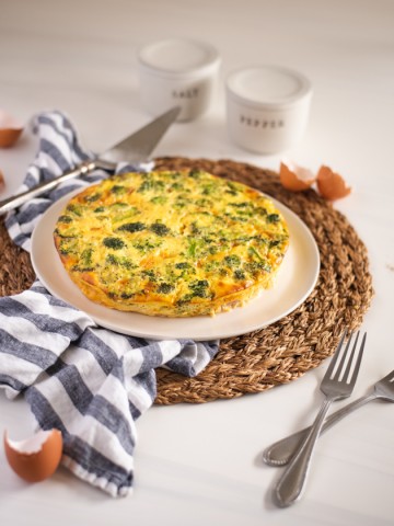 side view of a quiche on a rustic white table setting