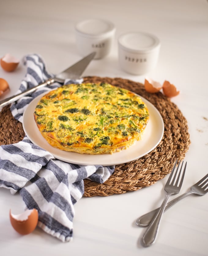 side view of a quiche on a rustic white table setting