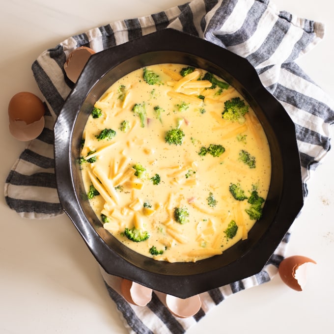 unbaked crustless quiche in black silicone pan