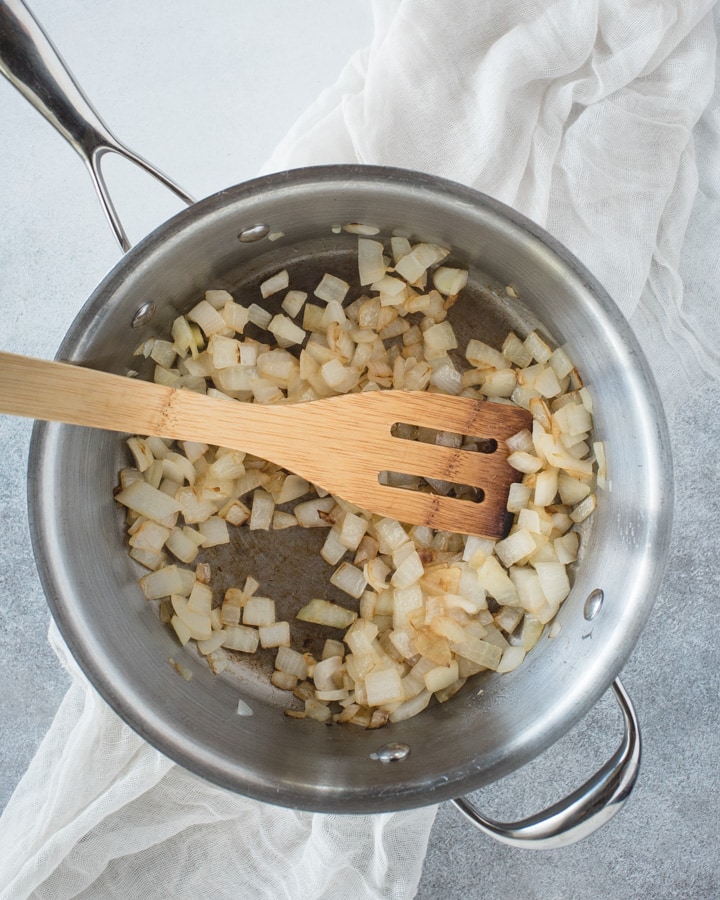 pan with wooden spoon, sauteed onions and garlic