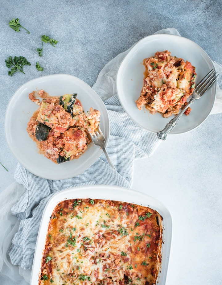 overhead picture of two plates and casserole dish of zucchini lasagna