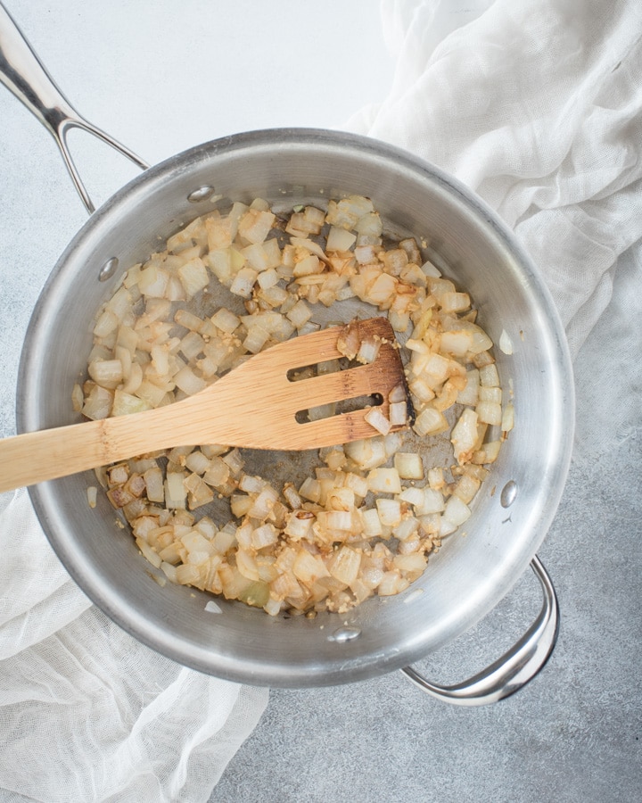 pan with sauteed onions and wooden spoon