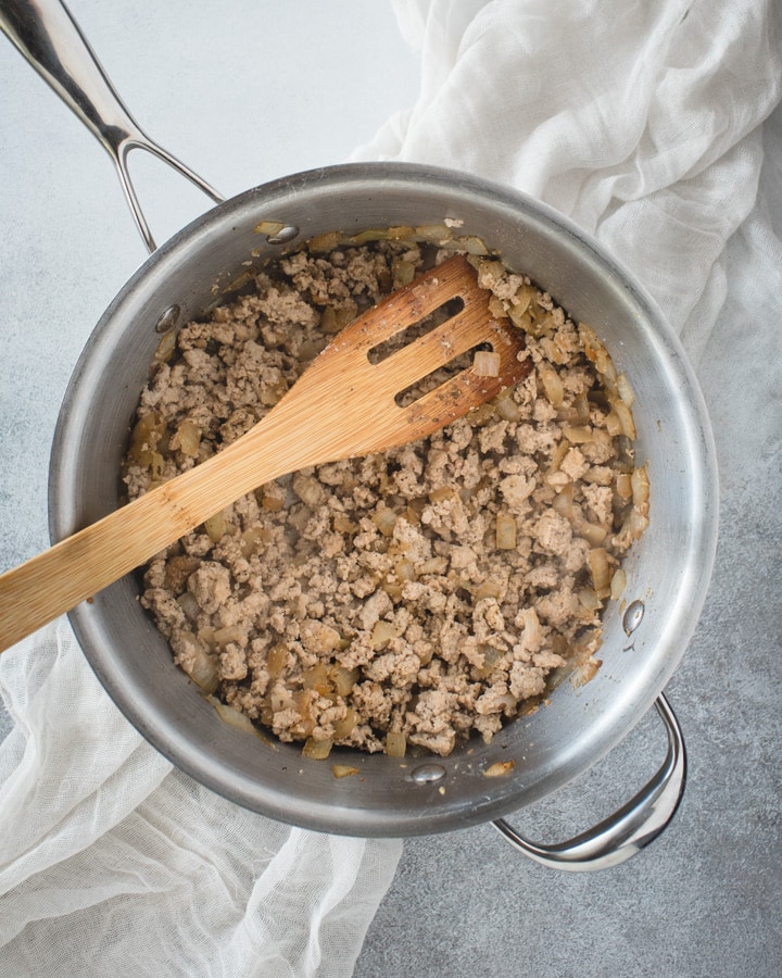 pan with cooked ground turkey and wooden spoon