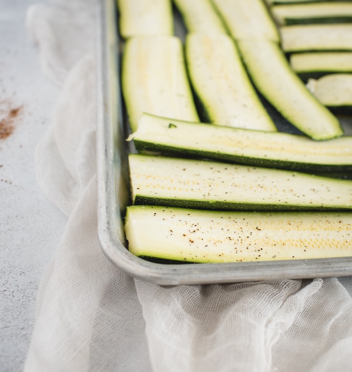 baking sheet with sliced zucchini laid out on it